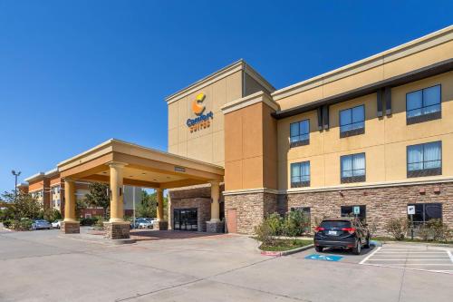 a hotel with a car parked in a parking lot at Comfort Suites Old Town Spring in Spring