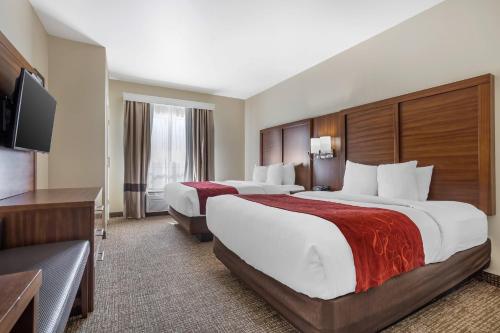 a hotel room with two beds and a flat screen tv at Comfort Suites Old Town Spring in Spring
