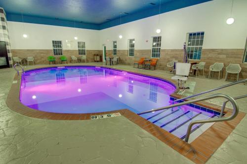 a large swimming pool with purple water in a building at Comfort Suites Newport News Airport in Newport News