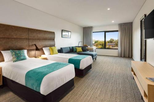 a hotel room with two beds and a couch at Quality Hotel Lakeside in Bendigo