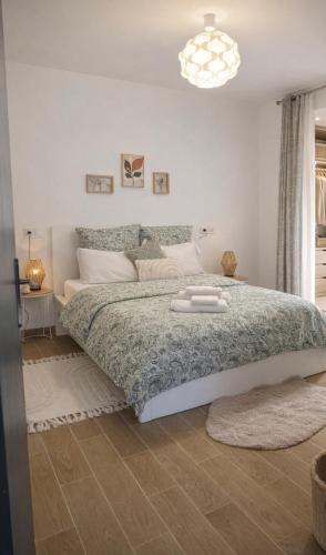 a bedroom with a bed with a green comforter at Appartement privé à 15mn de Paris et proche Enghien les bains in Groslay