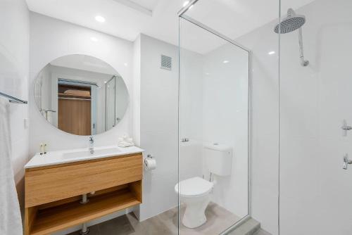 a bathroom with a toilet and a sink and a mirror at Comfort Resort Waters Edge in Port Macquarie