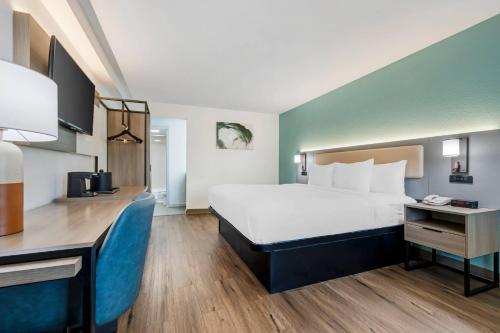 a hotel room with a large bed and a kitchen at Comfort Inn Sea World Area in San Diego