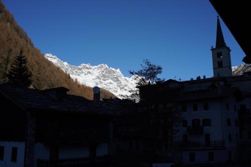 a building with a church and a mountain in the background at Hotel Al Caminetto in Valtournenche