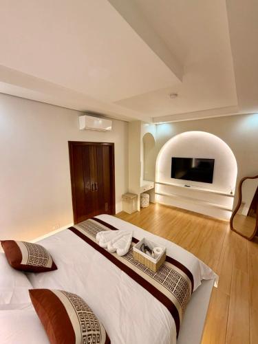 a bedroom with a large bed and a flat screen tv at Grand De Raj in Angeles
