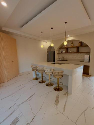 a kitchen with a large white island with bar stools at Grand De Raj in Angeles