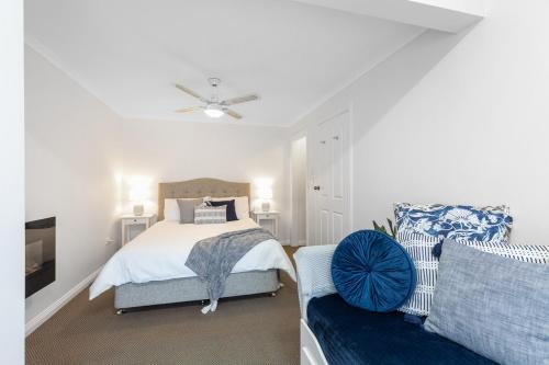 a bedroom with a bed and a couch at Charming CBD cottage - walk everywhere in Mount Gambier