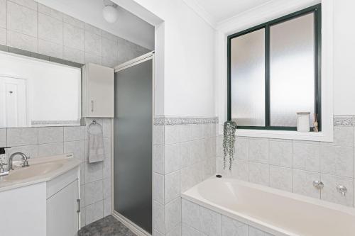 a white bathroom with a tub and a sink at Charming CBD cottage - walk everywhere in Mount Gambier