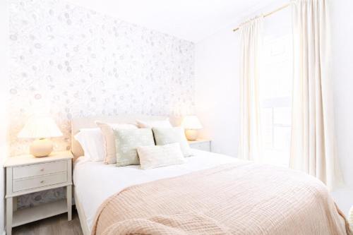 a white bedroom with a white bed and a window at DTWN Yale Wooster Square Laundry in New Haven