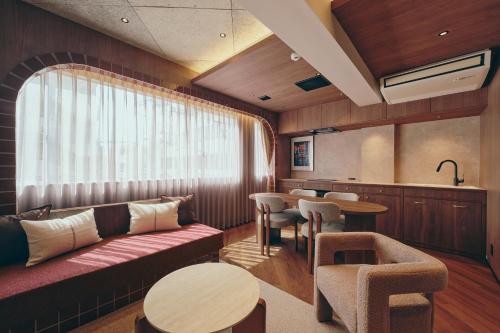 a living room with a couch and a table and chairs at illi Mani Shibuya in Tokyo