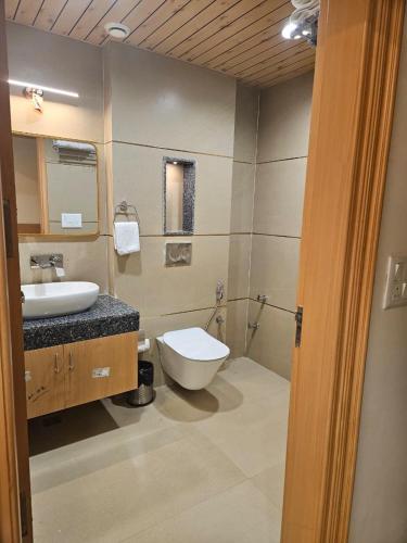 a bathroom with a toilet and a sink at The Grand Maan Palace and Resort- Near Vaishali Nagar I New Building in Jaipur