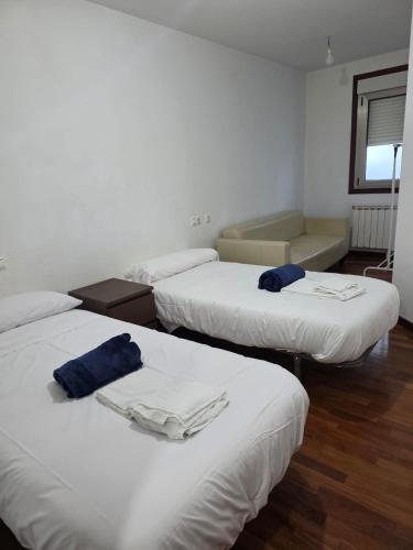a room with three beds and a couch in it at Smart English Rooms in O Mesón Do Vento 