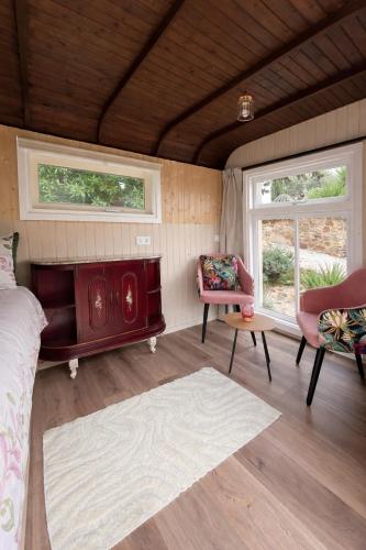 a bedroom with a bed and a chair and two windows at Casa Carla Andalucia, el Torcal in Almogía