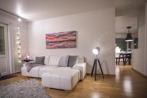 una sala de estar con un sofá blanco y una pintura en la pared en Inapolku, en Rovaniemi
