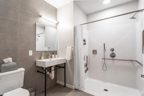 a white bathroom with a sink and a shower at Stylish Yale Wooster Square Downtown Laundry in New Haven