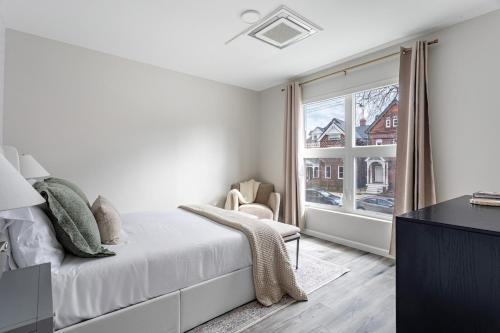 a white bedroom with a bed and a window at Stylish Yale Wooster Square Downtown Laundry in New Haven