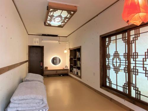 an empty room with a bed and a window at Architect's Cat Hanok - Sindal House Gyeongju in Gyeongju