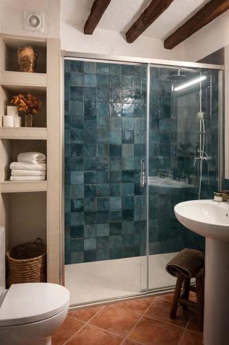 a bathroom with a glass shower and a sink at Casa Rural La Font in Sant Mateu