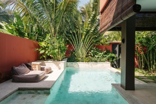 a swimming pool in the middle of a garden at Lasai Villas in Gili Islands