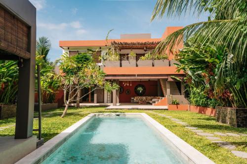 a villa with a swimming pool in front of a house at Lasai Villas in Gili Islands