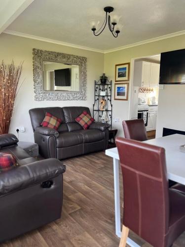 a living room with a couch and a table at Dragon Chalet 1 , 155 Sunbeach Holiday Village, Scratby in Scratby