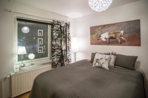 1 dormitorio con 1 cama y una foto de una vaca en Inapolku, en Rovaniemi