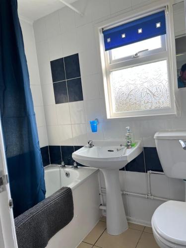 a bathroom with a sink and a toilet and a window at Dragon Chalet 1 , 155 Sunbeach Holiday Village, Scratby in Scratby