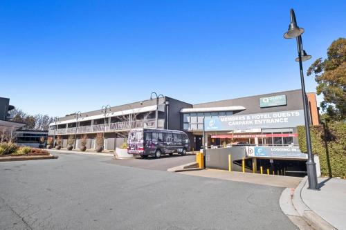 a bus is parked in front of a building at Quality Hotel Dickson in Canberra