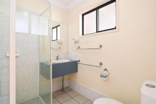 a bathroom with a glass shower and a sink at Econo Lodge Waterford in Loganlea