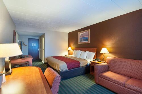 a hotel room with a bed and a couch at Quality Inn Near Pimlico Racetrack in Baltimore