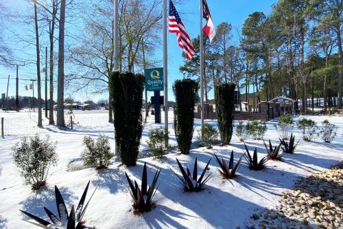 a snow covered park with an american flag and plants at Quality Inn Kenly I-95 in Kenly