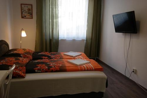 a bedroom with a bed with a tv on the wall at West City Apartments in Budapest