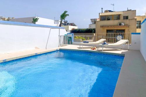 a swimming pool on the roof of a house at Pool & Sea Merill Apartments Mellieha in Mellieħa