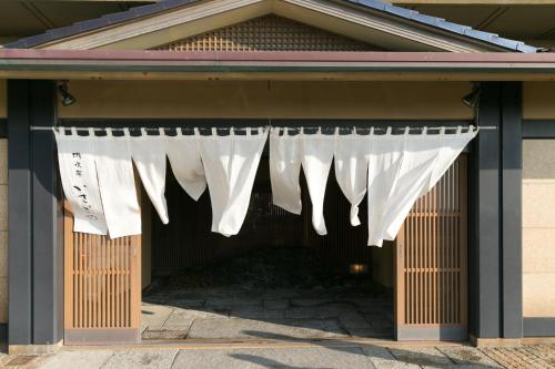 a building with a white curtain hanging from it at 游水亭いさごや in Tsuruoka