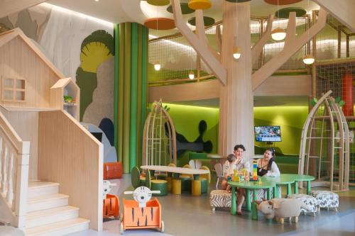 a doll house with people sitting at a table at Holiday Inn Resort Samui Bophut Beach by IHG in Bophut