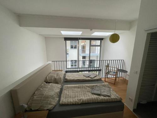 two beds in a room with a balcony at Modern Loft mit Terrasse in Vienna