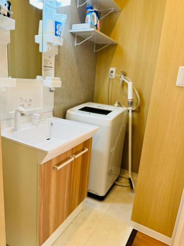 a bathroom with a sink and a washing machine at 日久の宿 in Kokubunji