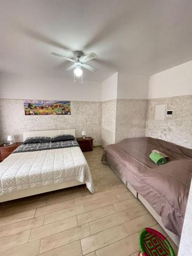 a bedroom with two beds and a ceiling fan at Villa Coco Monopoli in Monopoli