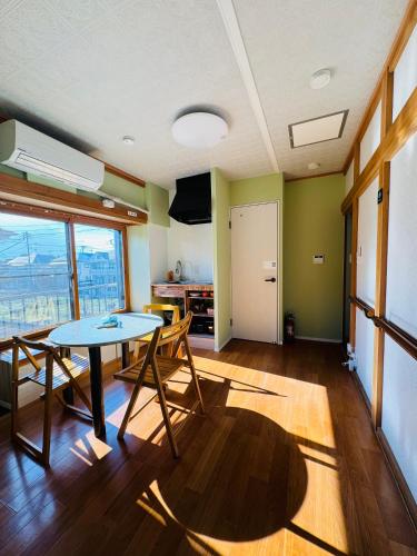 a living room with a table and chairs and a window at 日久の宿 in Kokubunji