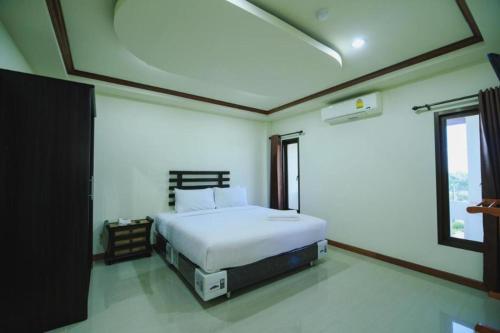 a bedroom with a white bed and a window at AmornSukhothai Hotel in Sukhothai