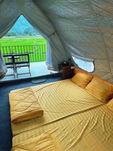 a large bed in a tent with a table at Sống Chill Homestay in Nam Yên
