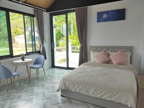 a bedroom with a bed and a table and chairs at Good View Guest House in Phatthalung