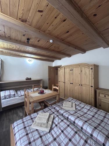 a bedroom with two beds and a wooden ceiling at Párty penzion Dolany in Čkyně