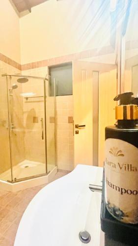 a bathroom with a shower and a bottle of wine at Mara Villa Katunayake - 5 Mins to Colombo Airport in Katunayaka