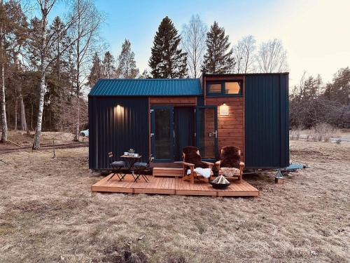 a tiny house with a dog sitting on a deck at Stockholm Archipelago by Tiny Away in Fagerdala
