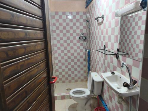a small bathroom with a toilet and a sink at Hotel El Golla in Er Rachidia