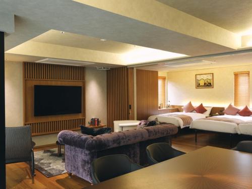 a hotel room with two beds and a flat screen tv at The GOAT AWAJI in Kusumoto