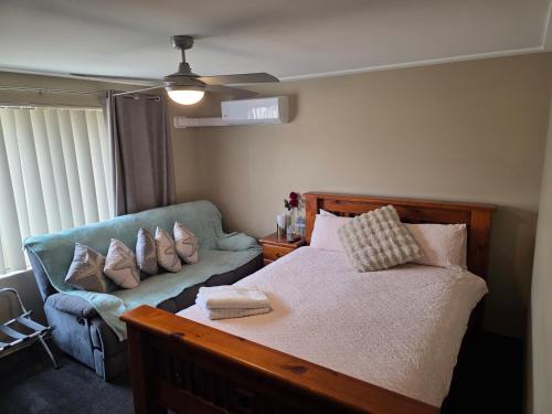 a bedroom with a bed and a couch at Sunset Beach B&B in Waggrakine