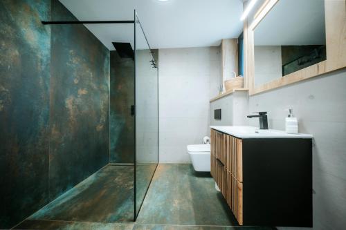 a bathroom with a glass shower and a toilet at Kotva By Momoland - Apartmán in Ružiná