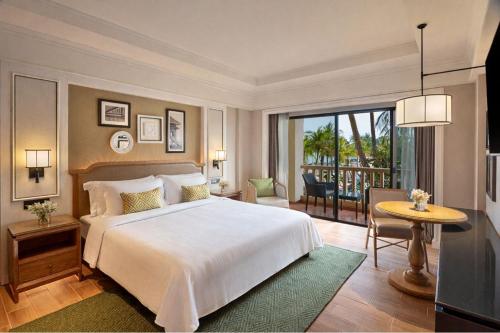 a bedroom with a large bed and a balcony at Dusit Thani Hua Hin in Cha Am